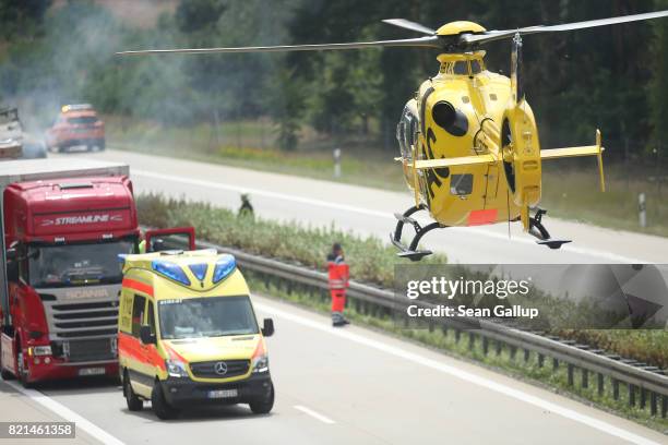 An ADAC helicopter lands next to the site where a truck caught fire following an accident on the A13 highway heading north on July 24, 2017 near...
