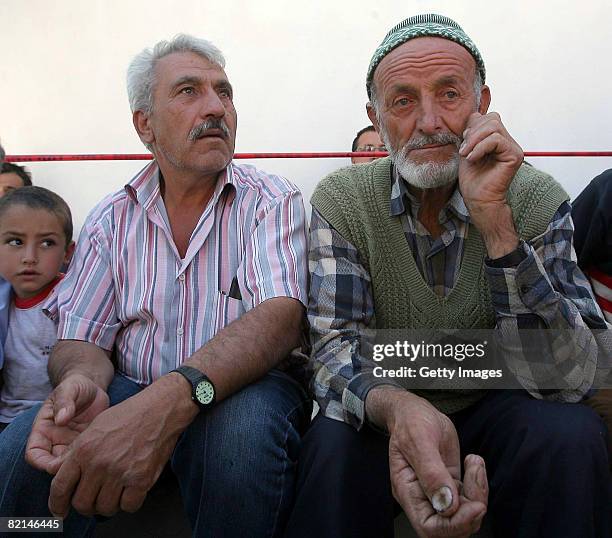 Relatives of the students wait as rescue operations continue at the wreckage of a girls' school dormitory from a nearby hill on August 1, 2008 in the...