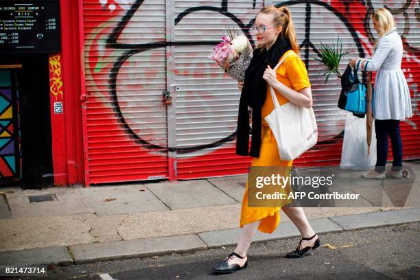 People shop at the Columbia Road Flower Market in east London on July 23, 2017. / AFP PHOTO / Tolga Akmen