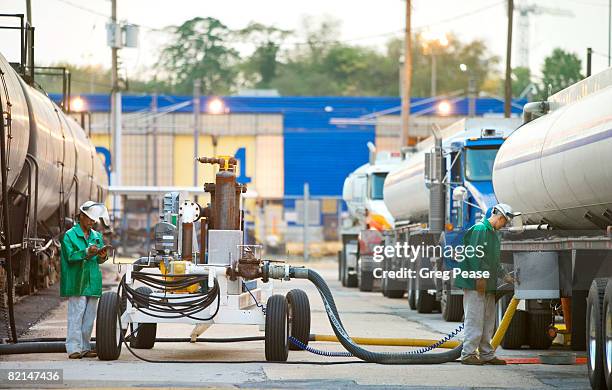 workers transferring ethanol from rail to truck - etanol fotografías e imágenes de stock