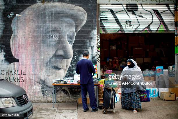 People shop near Brick Lane in east London on July 23, 2017. / AFP PHOTO / Tolga Akmen