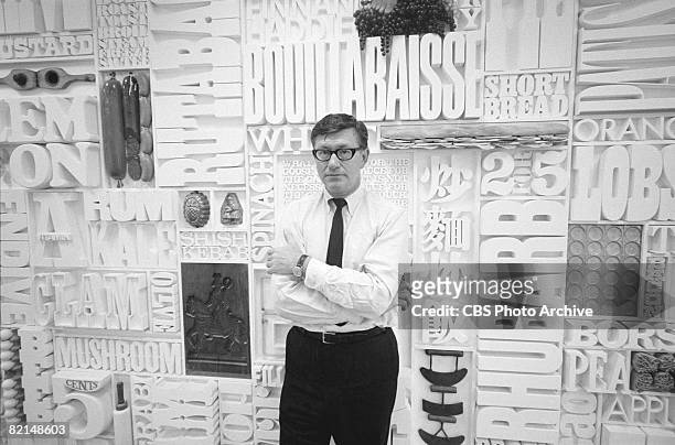 Director of Design Lou Dorfsman poses in the CBS Building cafeteria in front of the massive relief sculpture entitled 'Gastrotypographicalassemblage'...