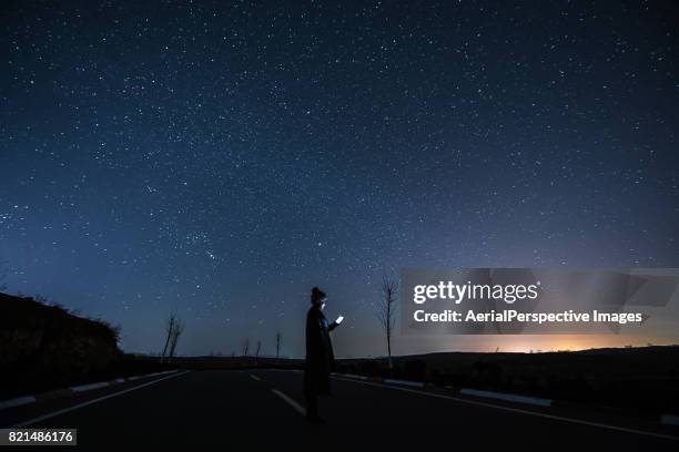 connecting at starry night - woman smartphone nature stockfoto's en -beelden