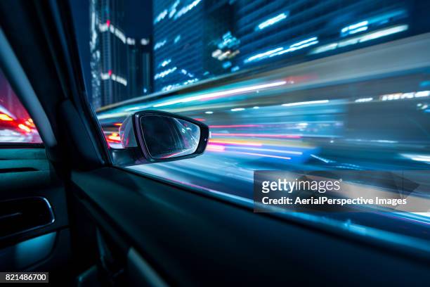 car driving in downtown at night - car spoiler stock-fotos und bilder