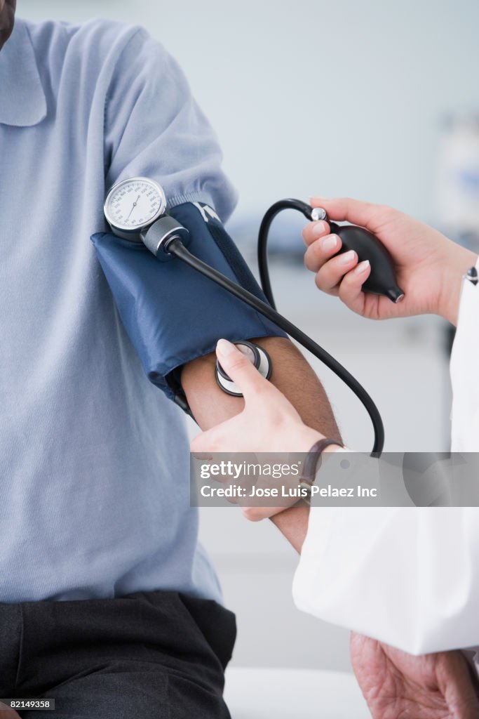 Middle Eastern doctor taking patient?s blood pressure