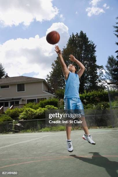 asian boy playing basketball - basketball hoop stockfoto's en -beelden