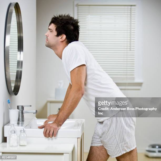 native american man looking in mirror - bathroom mirror 個照片及圖片檔