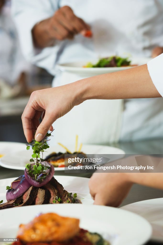 Chef putting garnish on plate of food