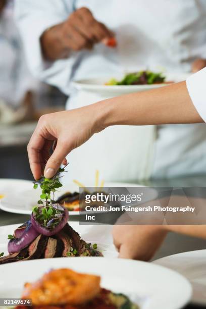 chef putting garnish on plate of food - chef finishing stock pictures, royalty-free photos & images