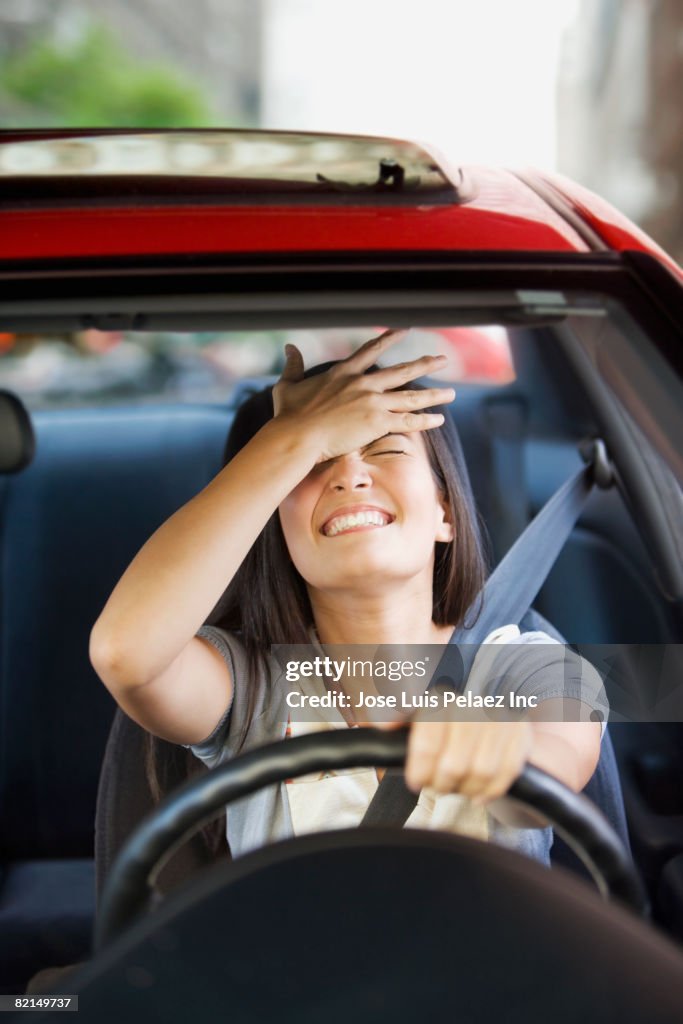 Frustrated Asian woman driving car
