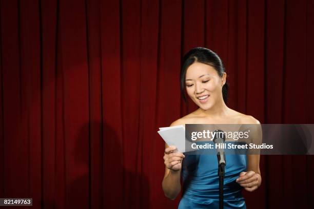 asian woman reading card on stage - discurso de agradecimiento fotografías e imágenes de stock