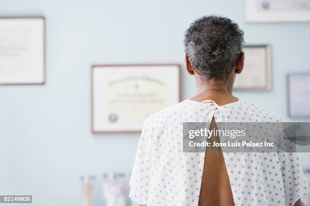 african man wearing hospital gown - patient medical gown stock pictures, royalty-free photos & images