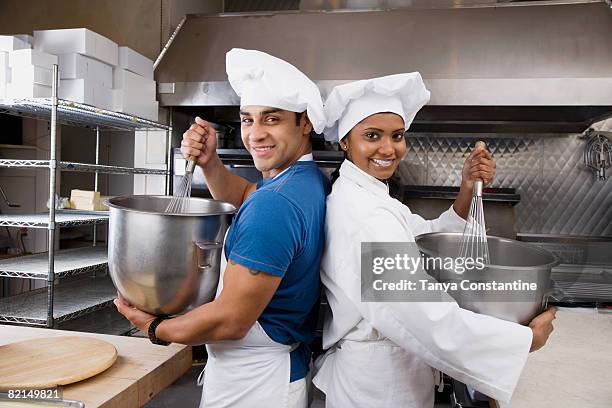 multi-ethnic pastry chefs mixing batter back to back - cooking contest stock pictures, royalty-free photos & images