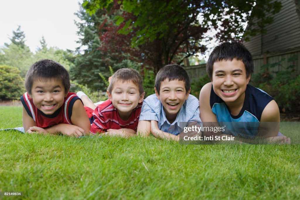 Asian brothers laying in grass