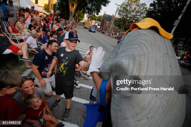 Landon Reynolds of Limington gives a high-five to Steamer the Clam during the Yarmouth Clam Festival parade.