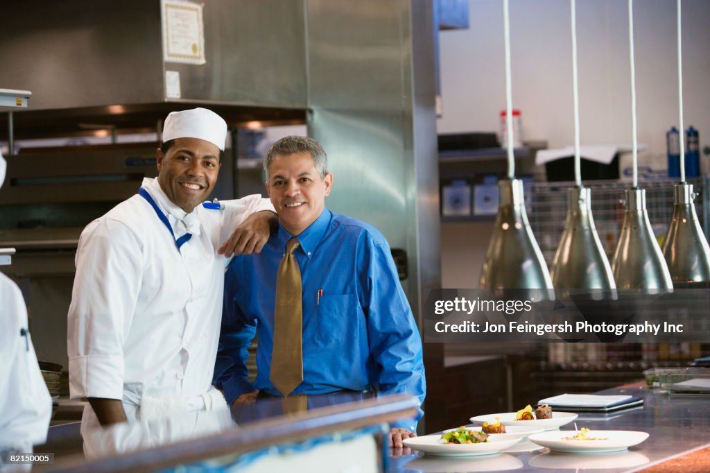 African chef and Hispanic businessmen in kitchen