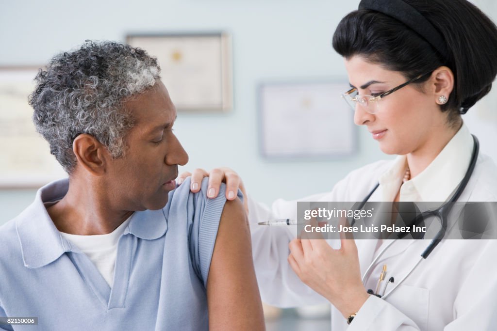 Middle Eastern female doctor giving shot to patient