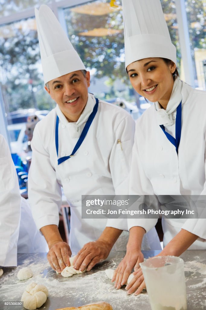 Multiethnic Bakers Rolling Dough HighRes Stock Photo Getty Images