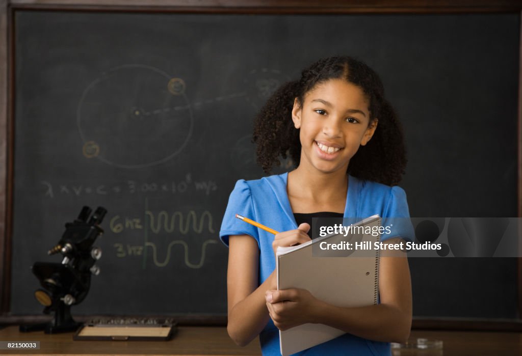 Mixed Race girl writing on notebook