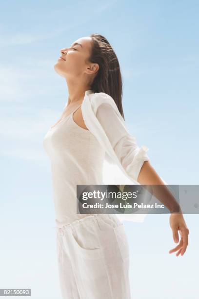 asian woman with face turned up to sun - woman happy raised arms closed eyes stock pictures, royalty-free photos & images