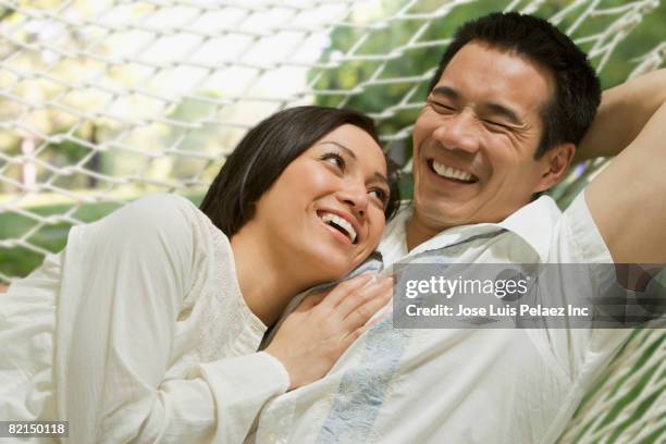 asian couple laying in hammock - vietnamese ethnicity imagens e fotografias de stock