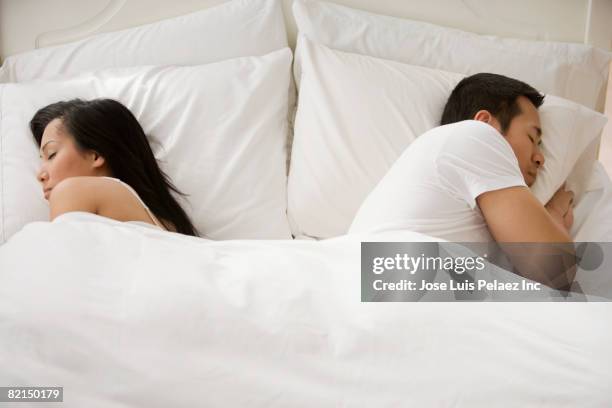 asian couple sleeping in bed - asian couple arguing stock-fotos und bilder