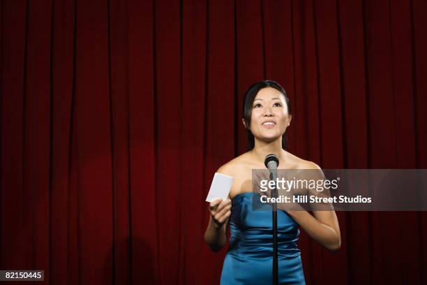 asian woman with hand on heart on stage - respect awards inside stock-fotos und bilder