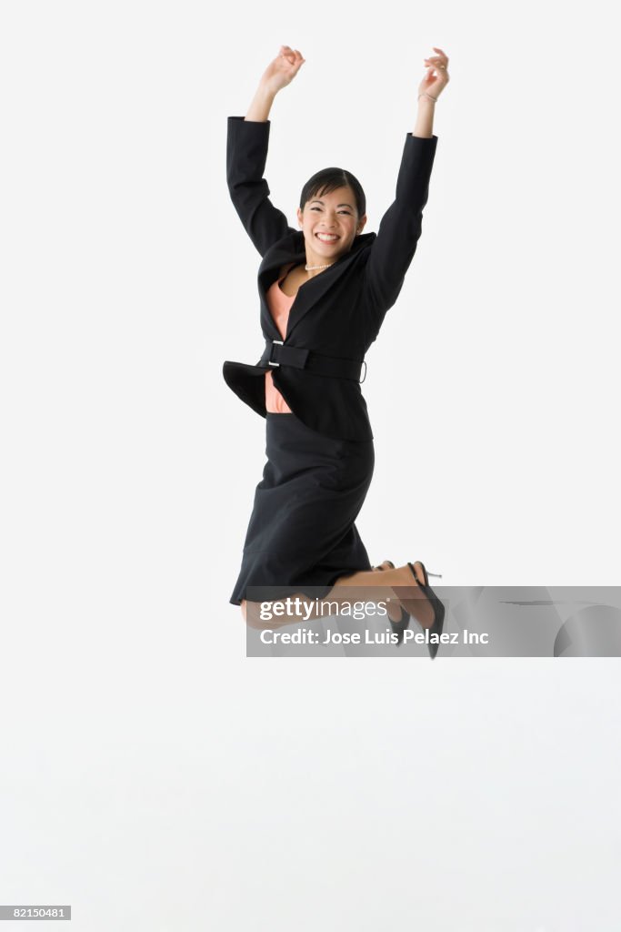 Asian businesswoman jumping in air