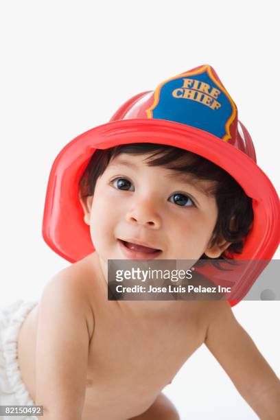 hispanic baby wearing fire chief helmet - boy fireman costume stock pictures, royalty-free photos & images