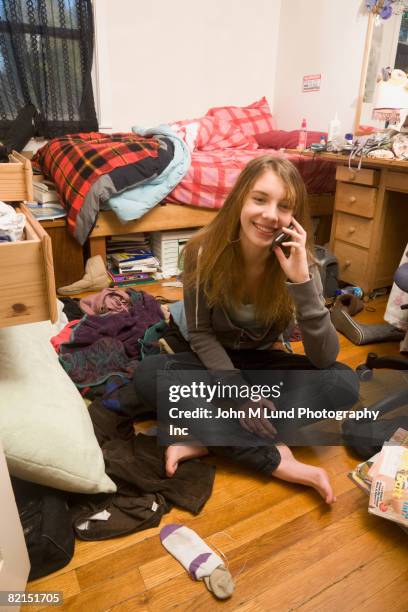 hispanic teenaged girl talking on cell phone - teen girl barefoot at home stock pictures, royalty-free photos & images