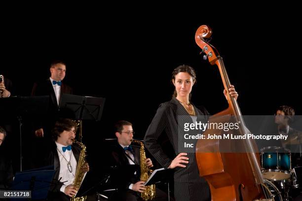 woman holding upright bass in front of band - soloist stock pictures, royalty-free photos & images