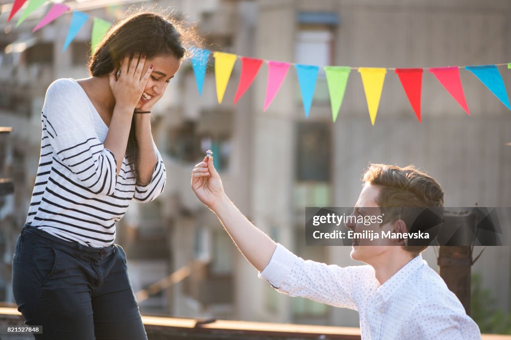 Kneeling young man proposing to his girlfriend