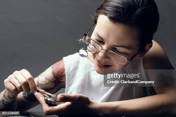 close up portrait of a female watchmaker at work - antique watch stock pictures, royalty-free photos & images