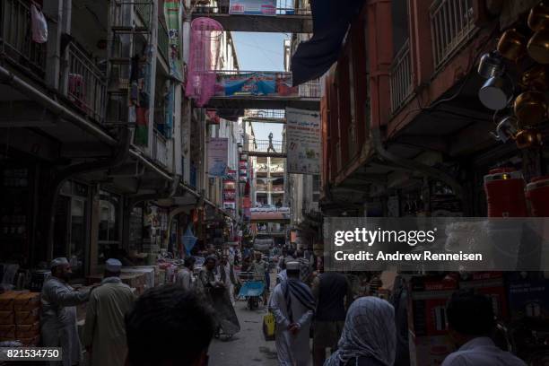 People navigate a busy street in the bazaar in Kabul's old city neighborhood on July 20, 2017 in Kabul, Afghanistan.Despite a heavy security presence...