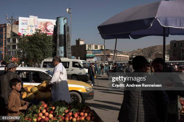 People and cars navigate a traffic circle just outside the bazaar in Kabul's old city neighborhood on July 20, 2017 in Kabul, Afghanistan. Despite a...