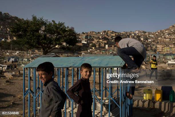 Boys play inside the Kart-e-Sakhion cemetery on July 20, 2017 in Kabul, Afghanistan. Despite a heavy security presence throughout the city, life...