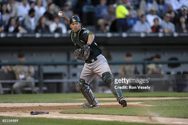 Kurt Suzuki of the Oakland A's fields a bunt during the game against the Chicago White Sox at U.S. Cellular Field in Chicago, Illinois on July 4,...