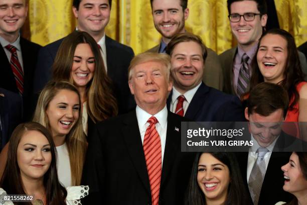 President Donald Trump poses for a group photo with outgoing interns at the White House in Washington on July 24, 2017.