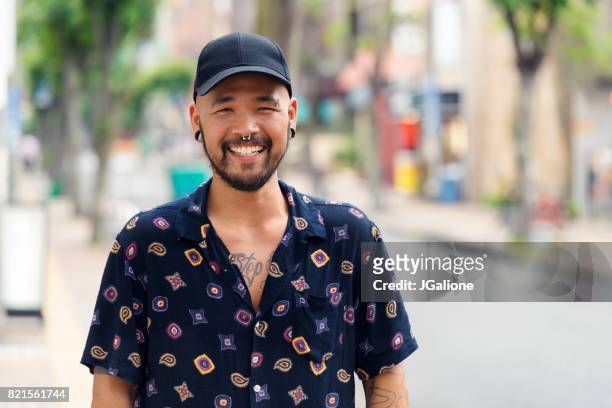 ritratto di giovane uomo asiatico fiducioso - multi colored shirt foto e immagini stock