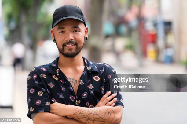 portrait of confident young asian man - baseball hat stock pictures, royalty-free photos & images