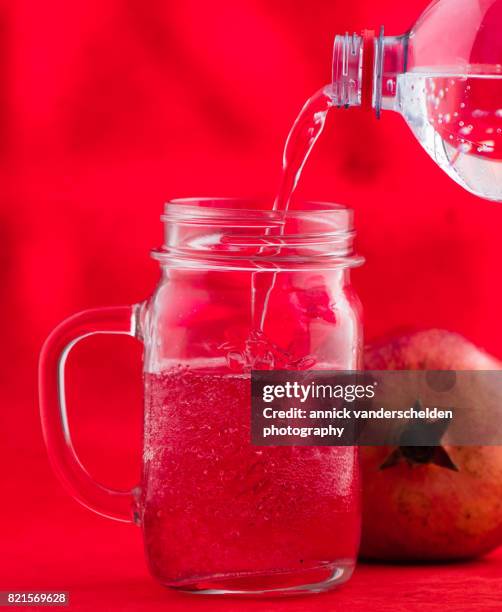 jar with grenadine and carbonated water. pomegranate. - glas bottle imagens e fotografias de stock