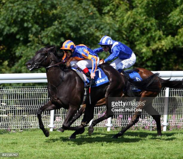 Halfway To Heaven ridden by Johnny Murtagh leads to win the Blue Square Nassau Stakes ahead of Muthabara run at Goodwood Racecourse on August 2 in...