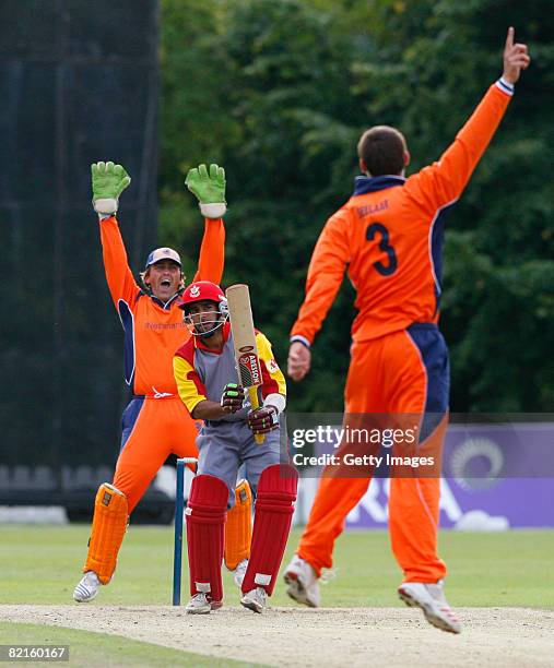 Pieter Seelaar of the Netherlands and teammate J. Smits celebrate as Steven Welsh of Canada is caught out during the Canada v Netherlands ICC World...