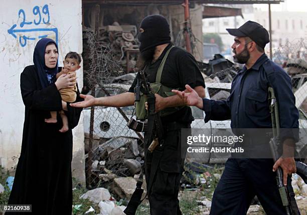 Palestinian woman carries her child as she tries to enter the Shujaia neighborhood during clashes between rival forces of Hamas and Fatah movements...