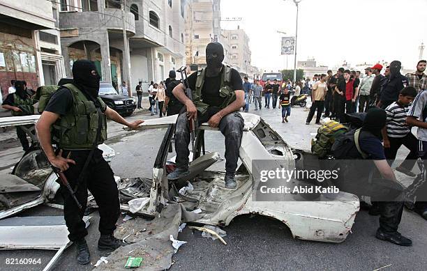 Masked members of Hamas take a rest during clashes between rival forces of Hamas and Fatah movements in the Shujaia neighborhood August 2, 2008 in...