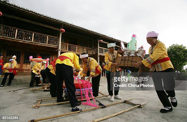 Tujia ethnic people prepare to carry the bride's dowry to the home of the groom during a wedding on August 2, 2008 in Qianjiang Tujia and Miao...