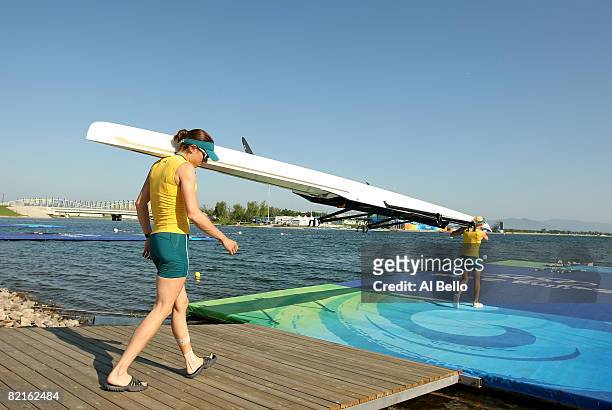 Marguerite Houston and Amber Halliday of Australia carry their boat to the water as they practice for the light weight double sculls at the Shunyi...