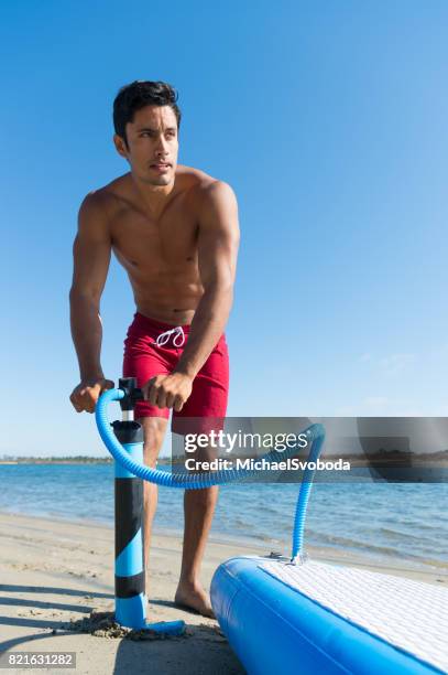 man stand up paddle board pompen - hobbie stockfoto's en -beelden