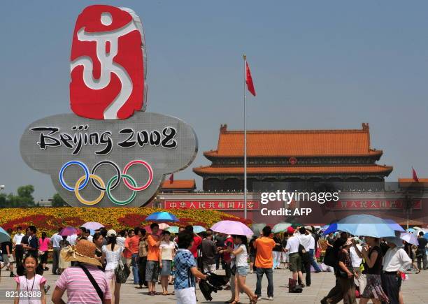 Oly-2008-China-environment-city-makeover by Gersende Rambourg People gather in front of the Beijing 2008 Olympic Games emblem in Tiananmen Square in...