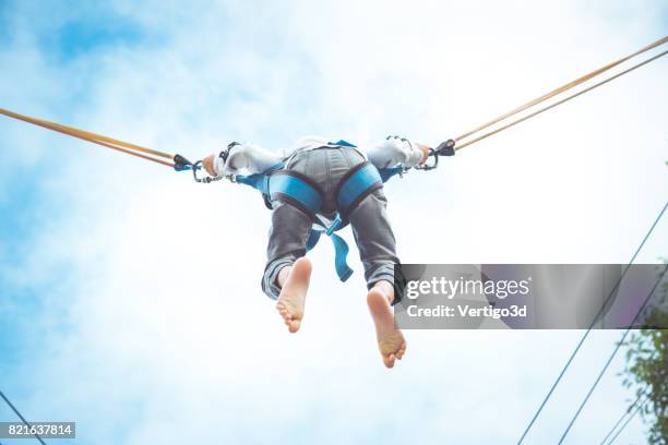 jongetje springen op de trampoline - bungee jump stockfoto's en -beelden